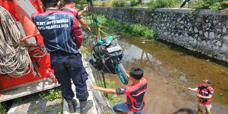 FOTO: Tim DPKP Kota Palangka Raya, pada saat mengevakuasi sepeda motor korban dari dalam drainase.