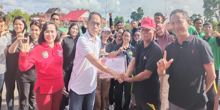 FOTO: IST/MATAKALTENG - Sekda Murung Raya Serampang (Baju putih) didampingi ketua Persani Murung Raya Regita saat menyerahkan piagam penghargaan kepada Kepala Dispursip Murung Raya M. Syahrial Pasaribu (topi merah) usai senam bersama di halaman kantor Bupati, Jumat 20 Oktober pagi.
