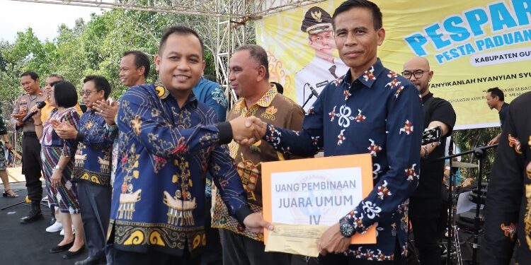 FOTO : DPRD GUMAS/MATA KALTENG - Anggota DPRD Kabupaten Gumas Evandi menyerahkan piagam dan uang pembinaan kepada Ketua Kontingen Kecamatan Sepang Sayusdi, yang berhasil meraih juara umum keempat, Sabtu, 28 Oktober 2023.