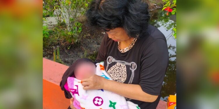 FOTO: RZL/MATAKALTENG - Bayi perempuan pada saat diberikan selimut, usai ditemukan di teras rumah warga.