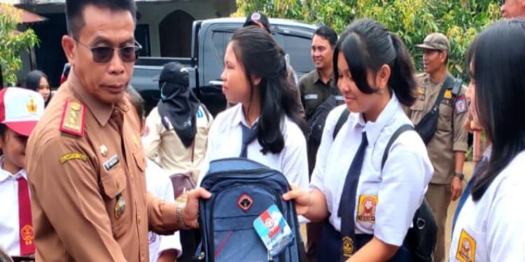 FOTO : MATAKALTENG - Pejabat (Pj) Bupati Murung Raya (Mura), Hermon, saat menyerahkan perlengkapan sekolah kepada anak korban kebakaran di Desa Konut.