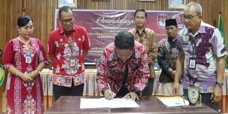 FOTO: PROKOM SERUYAN/MATA KALTENG - Pj Bupati Seruyan, Djainuddin Noor (tengah) saat menandatangani NPHD bersama Ketua KPU dan Bawaslu Kabupaten Seruyan di Aula Kantor Bupati Seruyan, kemarin.
