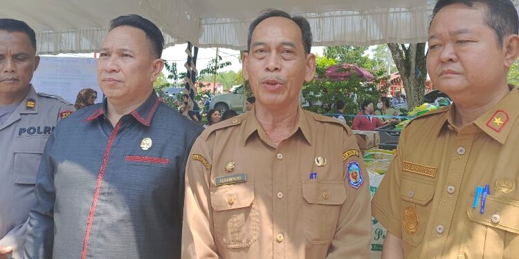 FOTO: ZON/MATAKALTENG - Plh Sekda Murung Raya Serampang (no 2 dari ujung kanan) saat diwawancarai awak media usai membuka kegiatan Gerakan Pangan Murah (GPM) di stadion mini Puruk Cahu.