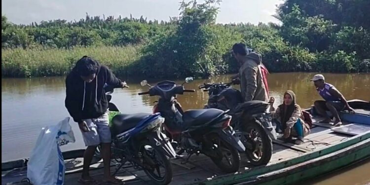 FOTO: AKH/MATAKALTENG - Warga menyeberang dari Jelai ke Natai Kuini menggunakan perahu.