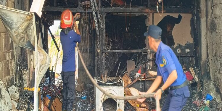 FOTO: RZL/MATAKALTENG - Petugas pemadam kebakaran pada saat melakukan pendinginan di lokasi kebakaran.