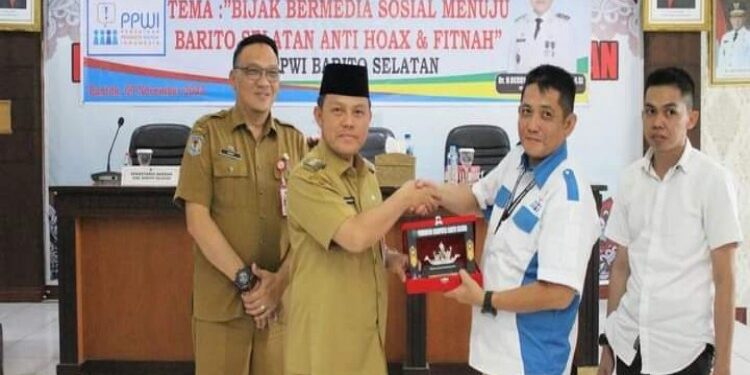 FOTO: MATAKALTENG - Pj Bupati Barsel Deddy Winarwan saat diberikan cindera mata oleh panitia penyelenggara dari Acara dialog publik dan deklarasi milenial Barsel anti hoaks dan fitnah.
