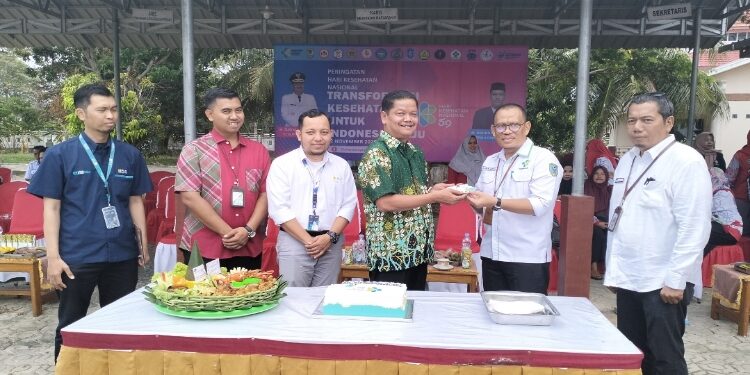 FOTO: PROKOM SERUYAN/MATA KALTENG - Pj Bupati Seruyan, Djainuddin Noor (tiga dari kiri) saat memberikan potongan tumpeng kepada Pj Sekda Seruyan sekaligus Kepala Dinkes Kabupaten Seruyan, Bahrun Abbas (dua dari kanan) dalam momen peringatan HKN di Halaman Kantor Dinkes setempat, kemarin.