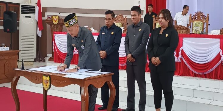 FOTO : DISKOMINFO SANTIK/MATA KALTENG - Bupati Gumas Jaya S Monong menandatangani dokumen persetujuan bersama terhadap raperda tentang APBD tahun 2024 dan Raperda tentang Perubahan Kesepuluh atas Perda Nomor 11 Tahun 2010 tentang Penyertaan Modal pemkab pada PDAM, di rapat paripurna ke-9 masa persidangan I tahun sidang 2023, Senin, 20 November 2023.