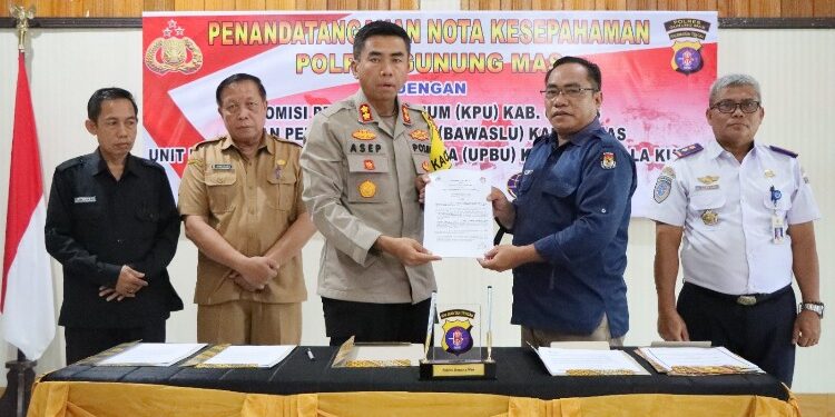 FOTO : HUMAS POLRES GUMAS/MATA KALTENG - Kapolres Gumas AKBP Asep Bangbang Saputra dan Ketua KPU Elfrinst Gunandry Tumon, ketika menunjukkan nota kesepahaman yang sudah ditandatangani, di aula bhayangkari mapolres setempat, Selasa, 21 November 2023.
