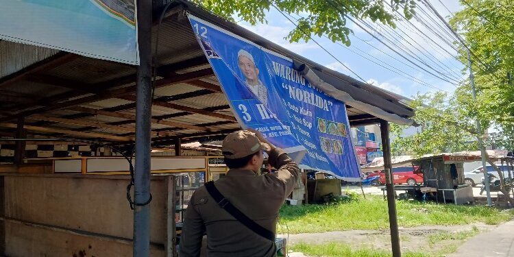 FOTO: RZL/MATAKALTENG - Tim gabungan penertiban APS saat menertibkan spanduk caleg.