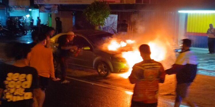 FOTO: MATAKALTENG - Warga pada saat berusaha memadamkan api di mobil korban.