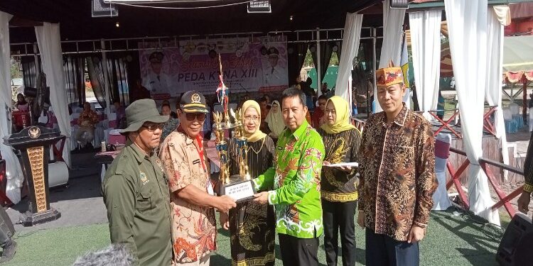 FOTO: AKH/MATAKALTENG - Pj Bupati Sukamara Kaspinor saat membagikan piala kepada kontingen yang memenangkan lomba pada PEDA KTNA XIII Tingkat Provinsi Kalteng.