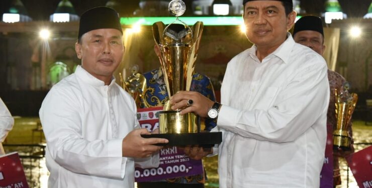 FOTO : IST/MATAKALTENG - Gubernur Sugianto Sabran menyerahkan Trofi Juara Umum MTQH XXXI Tingkat Provinsi Kalteng Tahun 2023 kepada Pj. Bupati Kobar Budi Santosa.