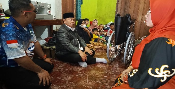 FOTO : DEVIANA/MATAKALTENG - Bupati Kotim Halikinnor saat membesuk dan menyerahkan kursi roda kepada warga di Jalan Sawit Raya, Minggu 26 November 2023.