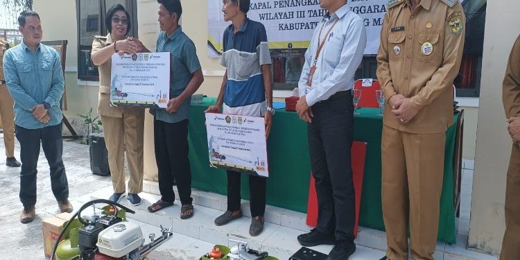 FOTO : DISKOMINFO SANTIK/MATA KALTENG - Wakil Bupati Gumas Efrensia LP Umbing didampingi Kepala DPKP Eigh Manto, saat menyerahkan secara simbolis bantuan perdana paket konversi BBM ke BBG untuk nelayan, di halaman kantor Kelurahan Tampang Tumbang Anjir, Senin, 27 November 2023.