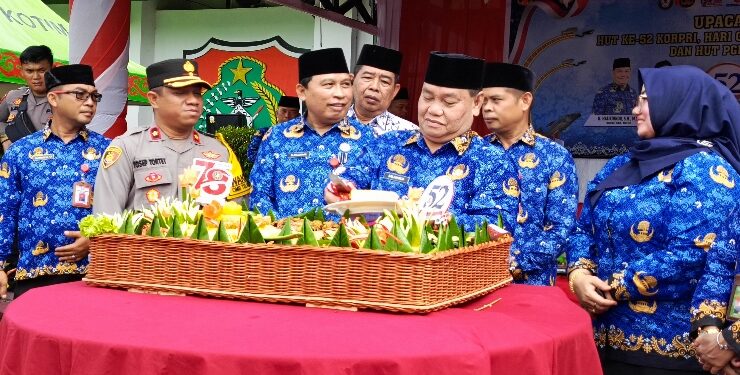 FOTO : DEVIANA/MATAKALTENG - Bupati Kotim Halikinnor saat memotong tumpeng di HUT PGRI dan Korpri, Rabu 29 November 2023.
