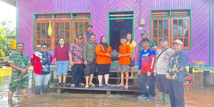 FOTO: IST/MATA KALTENG - Wakil Bupati Kotim Irawati saat memberikan bantuan kepada korban banjir di Desa Tumbang Mujam, Kecamatan Tualan Hulu, 30 November 2023.