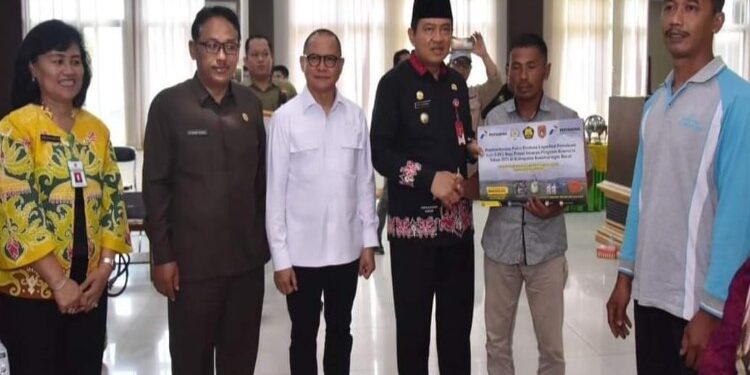 FOTO: IST/MATAKALTENG - Pj Bupati Kobar Budi Santosa saat menyerahkan secara simbolis bantuan pompa kepada petani dan nelayan di Kobar, belum lama ini