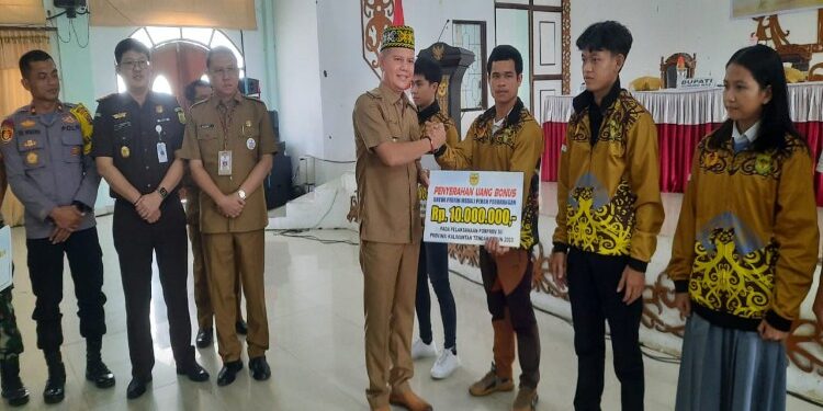 FOTO : DISKOMINFO SANTIK/MATA KALTENG - Bupati Gumas Jaya S Monong bersama Sekda Richard, Kajari Sahroni, Wakapolres Kompol Tri Wibowo dan Kepala Disdikpora Aprianto, menyerahkan secara simbolis uang bonus ke atlet peraih medali dan uang saku kontingen Porprov XII Kalteng, di GPU Damang Batu, Selasa, 5 Desember 2023.
