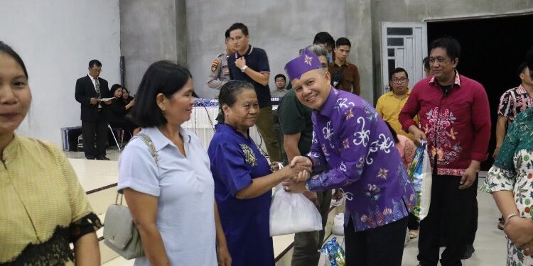 FOTO : DISKOMINFO SANTIK/MATA KALTENG -  Bupati Gumas Jaya S Monong didampingi Wakil Bupati Efrensia LP Umbing, Kapolres AKBP Asep Bangbang Saputra, memberikan bantuan kepada lansia dan peserta didik pada acara safari natal pemkab, di Kelurahan Tehang, Kecamatan Manuhing Raya, Senin, 4 Desember 2023.