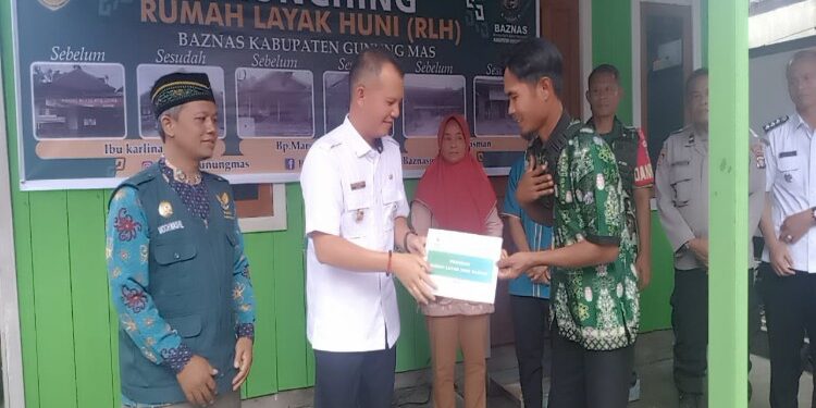FOTO : DISKOMINFO SANTIK/MATA KALTENG - Bupati Gumas Jaya S Monong didampingi Ketua Baznas Moch Washil, ketika menyerahkan rumah yang sudah direnovasi kepada pemiliknya, Rabu, 6 Desember 2023.