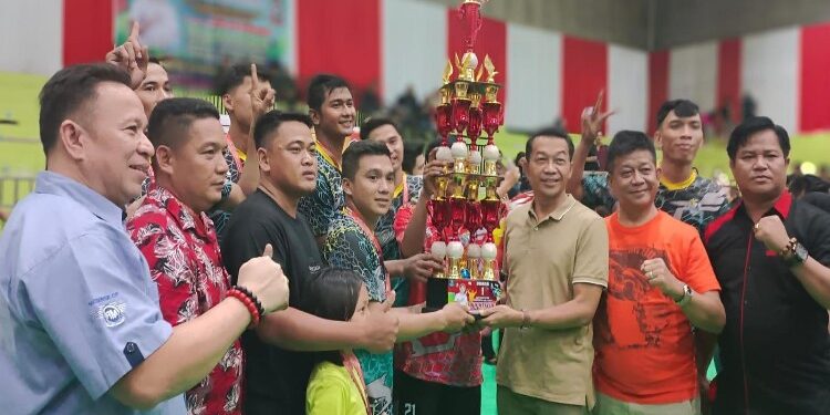FOTO: MATAKALTENG - Bupati Murung Raya (Mura), Perdie M. Yoseph menyerahkan piala beserta uang tunai sebanyak Rp 30 juta, mendali dan piagam kepada pemenang juara I putra pada turnamen bola voli Bupati cap tahun 2023 di Gedung Olahraga Tana Malai Tolung Lingu (TMTL) Puruk Cahu, Kamis (14/9/2023).