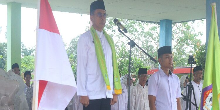 FOTO: MATAKALTENG - Penjabat (Pj) Bupati Murung Raya (Mura), Hermon pimpin upacara peringatan Hari Santri Nasional (HSN) yang berlangsung di Pondok Pesantren Nailul Authar, di Desa Danau Usung, Minggu (22/10/2023).