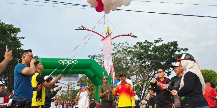 FOTO: MATAKALTENG - Wakil Bupati Mura, Rejikinoor melepas ribuan masyarakat yang hadir dan mengikuti jalan sehat tersebut berpusat di Bundaran Emas Kota Puruk Cahu, Jumat (18/8/2023).