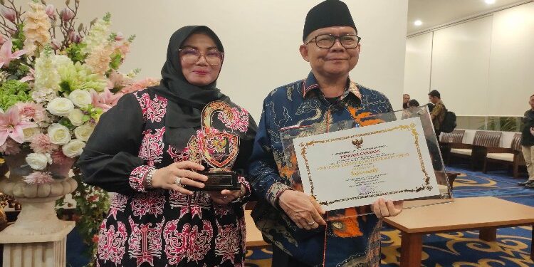 FOTO : IST/MATAKALTENG - Wakil Bupati Kotim Irawati dan Kepala Diskominfo Marzuki saat menunjukkan penghargaan Keterbukaan Informasi Badan Publik belum lama ini.