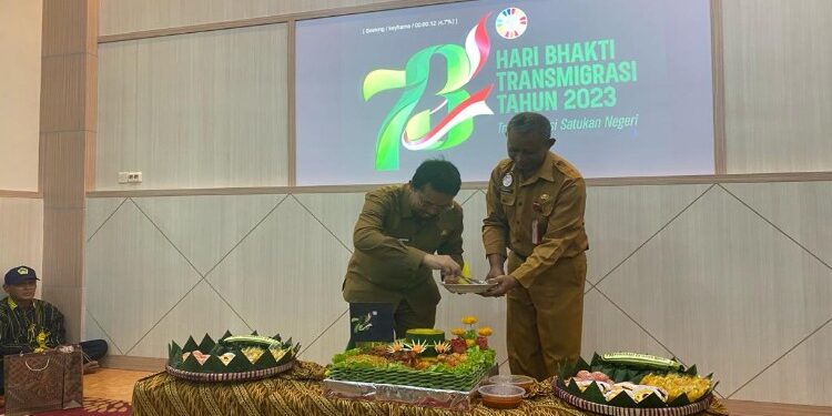 FOTO: AKH/MATAKALTENG - Pj Bupati Sukamara Kaspinor saat menyerahkan potongan tumpeng kepada Kepala Dinas Nakertrans Sukamara, Warianto.