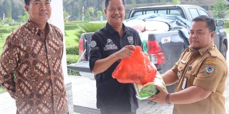 FOTO: PROKOM SERUYAN/MATA KALTENG - Pj Bupati Seruyan, Djainuddin Noor (tengah) saat menyerahkan secara simbolis paket bantuan masyarakat kurang mampu kepada Camat Danau Sembuluh.