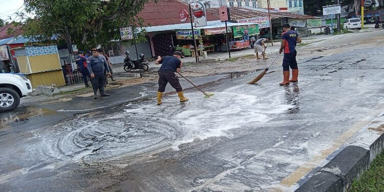 FOTO: RZL/MATAKALTENG - Petugas Damkar Kota Palangka Raya, pada saat melakukan pembersihan jalan yang tertumpah solar dan oli.