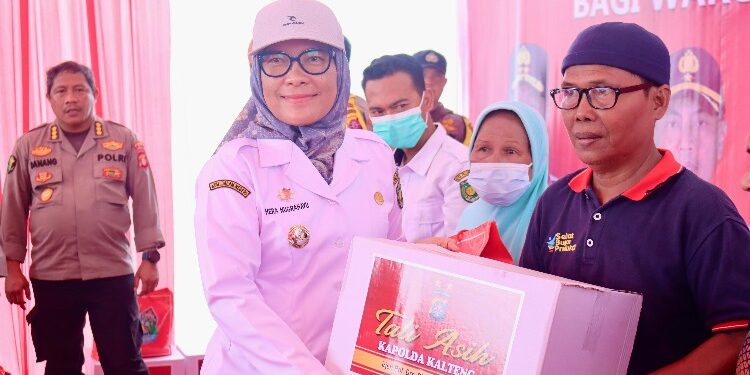 FOTO: RZL/MATAKALTENG - Pj Wali Kota Palangka Raya, Hera Nugrahayu saat menyerahkan bantuan kepada warga di bakti sosial Polda Kalteng.