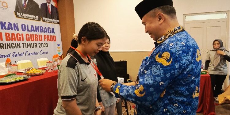 FOTO: DEVIANA/MATAKALTENG - Kadispora Kotim Wim RK. Benung saat mengalungkan kartu tanda peserta, Kamis 21 Desember 2023.
