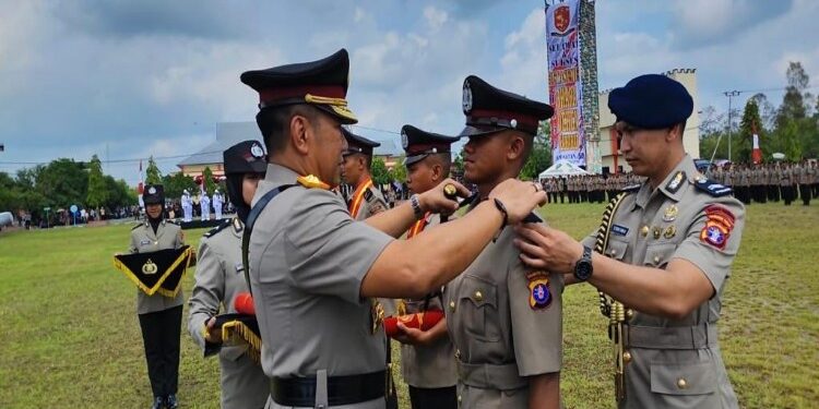 FOTO: MATAKALTENG - Kapolda Kalteng, Irjen Pol Djoko Poerwanto, pada saat memasangkan tanda pangkat efektif kepada salah seorang lulusan terbaik Bintara Polri.