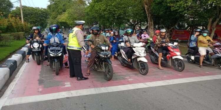 FOTO: RZL/MATAKALTENG - Kanit Kamsel Satlantas Polresta Palangka Raya, Ipda Eko Hermawan, pada saat mengedukasi salah seorang pengendara.