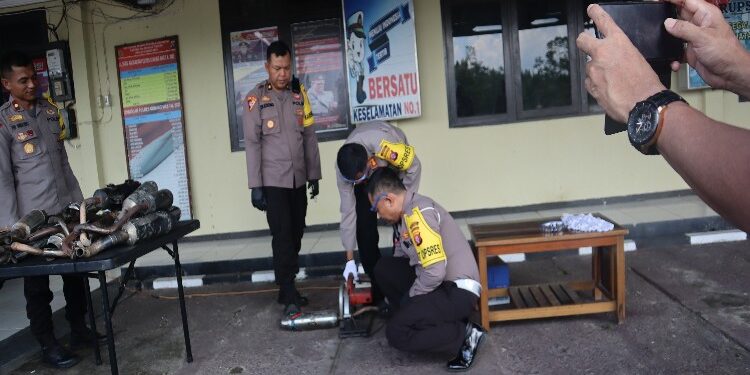 FOTO : HUMAS POLRES GUMAS/MATA KALTENG - Kapolres Gumas AKBP Asep Bangbang Saputra, Wakapolres Kompol Tri Wibowo dan Kabag Ops Kompol Budiono, memusnahkan knalpot brong dengan cara dipotong, Jumat, 22 Desember 2023.
