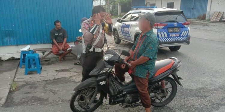 FOTO: RZL/MATAKALTENG - Kasat Lantas Polresta Palangka Raya, AKP Salahiddin, pada saat menegur secara humanis salah seorang pengendara yang tak menggunakan helm.