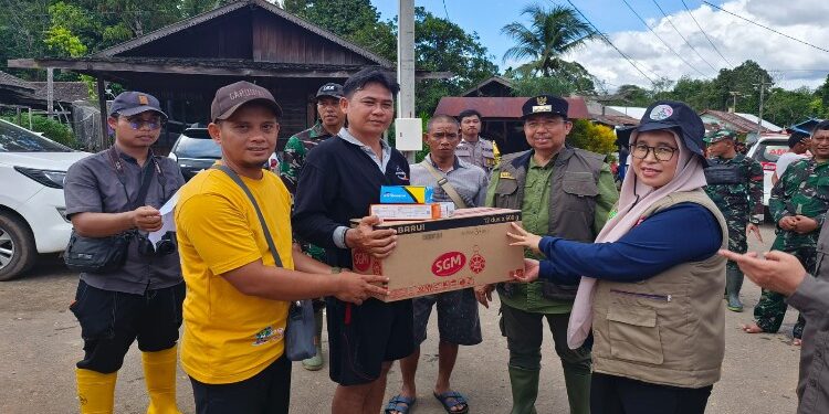 FOTO: IST/MATAKALTENG - Kepala Dinas Kesehatan Sukamara bersama Pj Bupati Sukamara Kaspinor saat menyerahkan kepada warga terdampak banjir.