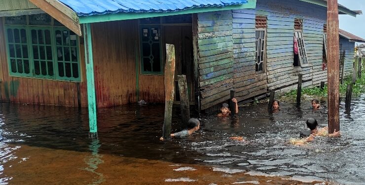 FOTO : IST/MATAKALTENG - Warga asik mandi banjir di sekitar halaman rumah