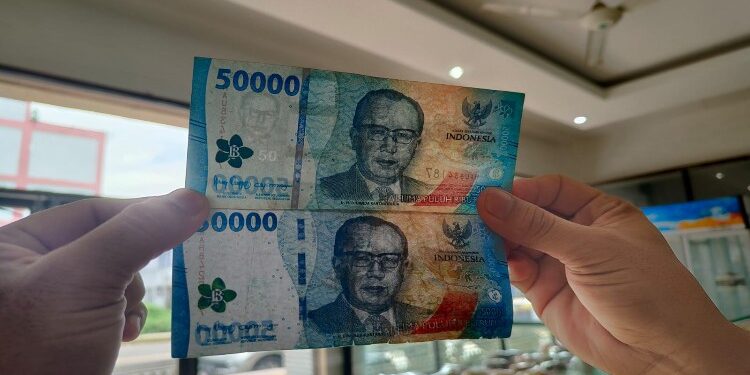 FOTO: IST/MATAKALTENG - Karyawan toko kue saat memperlihatkan perbedaan uang asli dan uang palsu (bawah) di Jalan A Yani.