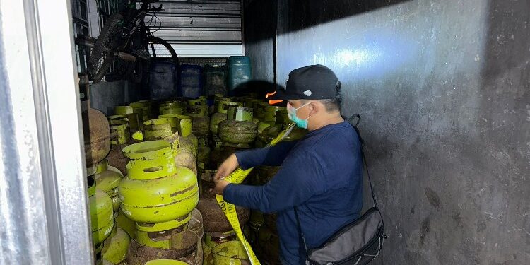 FOTO: IST/MATA KALTENG - Polisi saat memasang garis Polisi di TKP pangkalan gas LPG ilegal di Baamang.