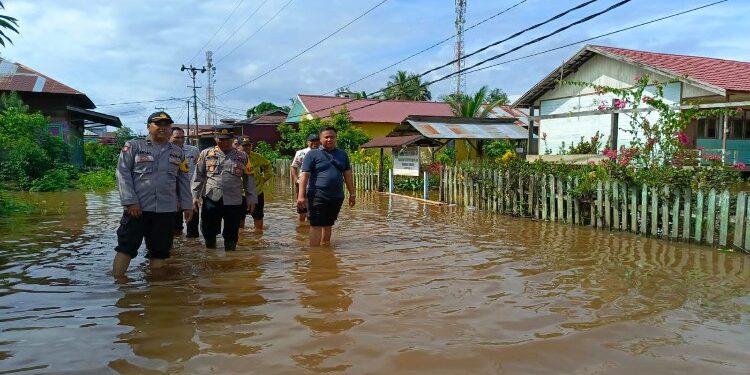FOTO: MATAKALTENG - Kapolsek Dusun Utara, AKP Agus Setyono bersama Pemerintah Kecamatan setempat saat meninjau langsung kondisi daerahnya yang mulai terendam banjir.
