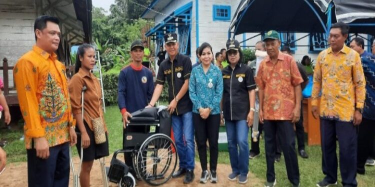 FOTO : DISKOMINFO SANTIK/MATA KALTENG - Bupati Gumas Jaya S Monong bersama Wakil Bupati Efrensia LP Umbing dan Ketua TP-PKK Mimie Mariatie Jaya S Monong, ketika menyerahkan bantuan kursi roda kepada penyandang disabilitas, di Kelurahan Tumbang Napoi, Kecamatan Miri Manasa, belum lama ini.