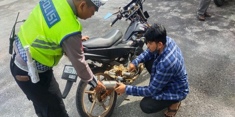 FOTO: RZL/MATAKALTENG - Pelanggar knalpot brong pada saat melepaskan knalpot brong nya.