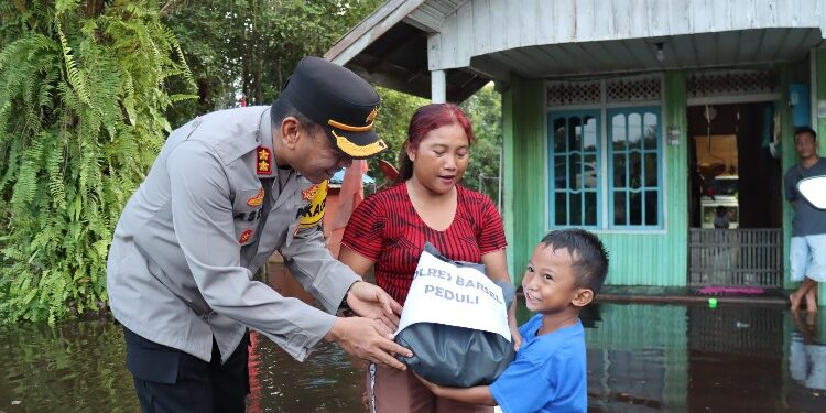 FOTO: IST/MATAKALTENG - Kapolres Barsel AKBP Asep Bangbang Saputra saat memberikan bansos bagi warga yang terdampak banjir.