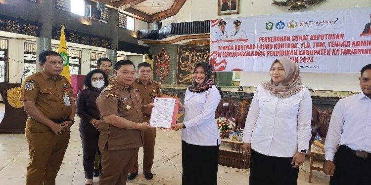 FOTO: DEVIANA/MATAKALTENG - Bupati Kotim Halikinnor saat menyerahkan SK perpanjangan kontrak tahun 2024 kepada perwakilan tekon guru, Senin 29 Januari 2024.