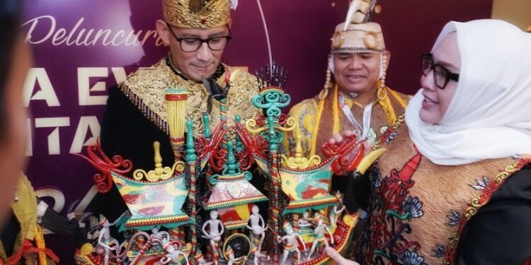 FOTO: MATAKALTENG - Kepala Dinas Adiah Chandra Sari menyerahkan cinderamata yang terbuat dari bahan getah nyatu kepada Menparekraf Sandiaga Uno.