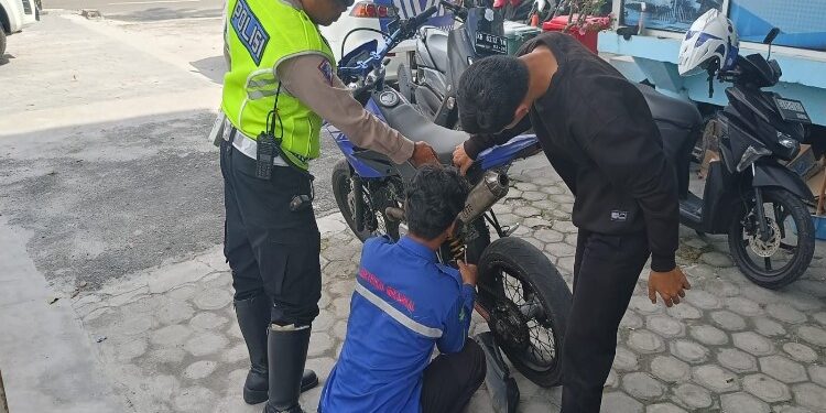 FOTO: RZL/MATAKALTENG - Personel Satlantas Polresta Palangka Raya, pada saat memberikan tindakan secara simpatik kepada pengguna knalpot brong.