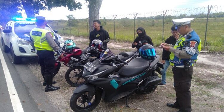 FOTO: RZL/MATAKALTENG - Personel Satlantas Polresta Palangka Raya, pada saat memberikan teguran kepada para pemuda yang tengah nongkrong di kawasam Bandara Tjilik Riwut Palangka Raya.